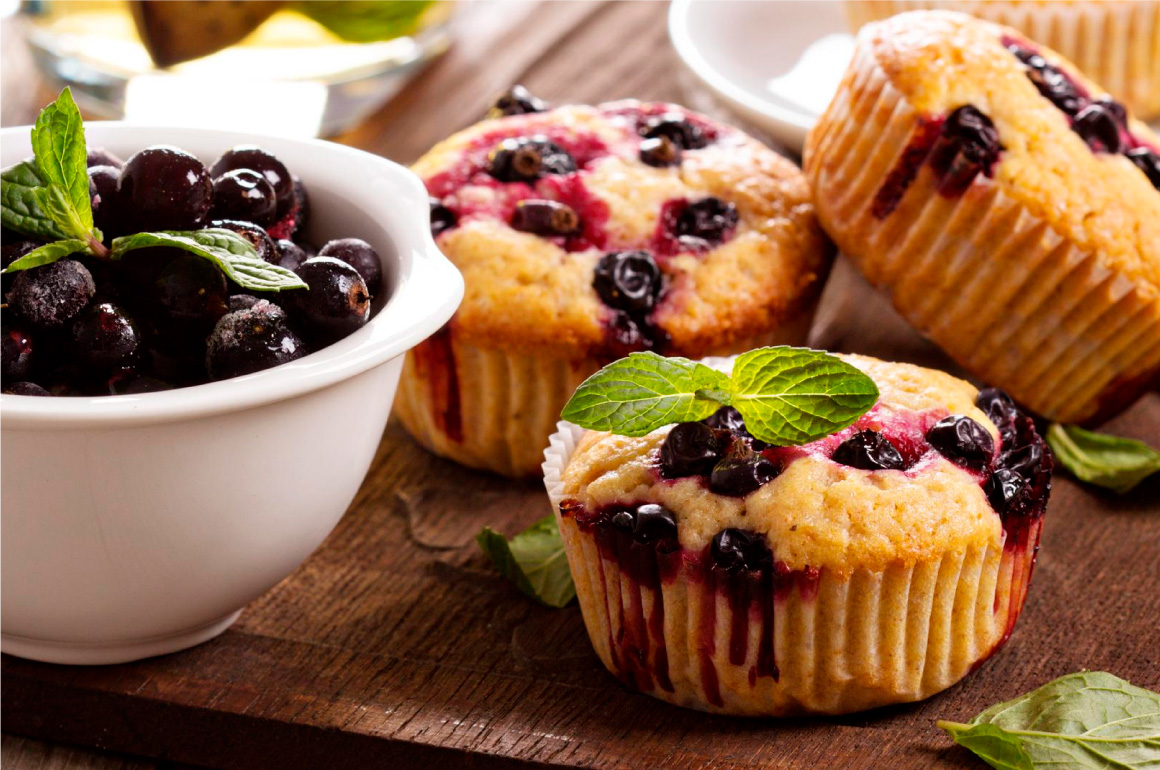 Heidelbeer-Haselnuss-Muffins neben einer Schale Heidelbeeren